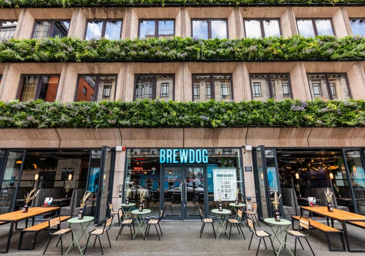 a group of tables and chairs in front of a building at BrewDog DogHouse Manchester in Manchester
